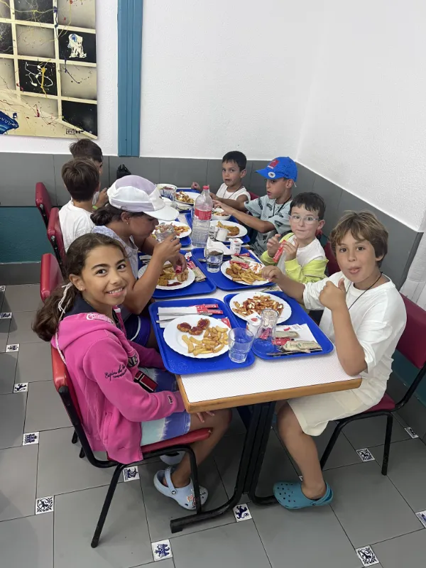 Niños comiendo en el comedor del campamento